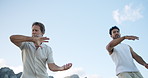 Men, mentor and tai chi with student for martial art lesson, practice or balance in nature. Blue sky, male people or kung fu teacher with slow movement for mindfulness, chakra or meditation in motion