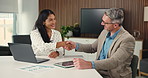 Business, people and meeting with handshake in office for partnership, agreement and finance deal. Smile, team and shaking hands with laptop for financial approval, negotiation and funding proposal