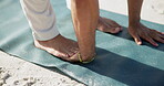 Yoga, stretching and feet with man at beach for health, holistic wellness and spiritual balance. Warm up, healing routine and self care with hands of person outdoor for zen, peace and awareness