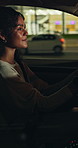 Night, driving and happy woman in car on city street, vehicle navigation or commute to destination. Red light, stop signal or person in dark automobile for travel, watch traffic or safe road practice