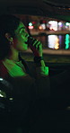 Woman, sining and dancing in car at night for travel, listening to music and groovy karaoke. Female person, driving and rhythm in vehicle for nightlife commute, streaming playlist and adventure audio
