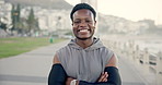Face, fitness and black man with arms crossed, seaside and training for wellness benefits. Happy, outdoor or healthy person with smile workout or challenge for body development, athlete and exercise