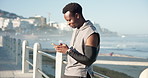 Typing, athlete and man with smartphone, outdoor and communication with contact on social media app. Texting, online and black person with mobile for message, fitness and runner with smile for chat