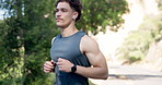 Nature, fitness and man with running for workout, training or wellness in morning with earphones. Health, runner and male athlete listening to music for cardio exercise outdoor in park for practice.