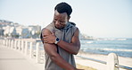Man outdoor, stretching and shoulder pain from exercise challenge, difficult workout or medical issue. Hurt, black person and athlete on promenade with muscle inflammation, problem and sports injury.