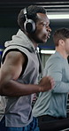 Happy man, running and treadmill with headphones in gym for workout or cardio exercise. Active, male person or runner with smile, music or sound for indoor training or weightloss in health club