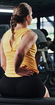 Woman, fitness and back pain with discomfort in gym for workout accident, sprain or strain. Active, female person or sore spine with injury or bad posture for overworked exercise or muscle tension