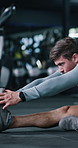 Breathing, exercise and stretching with man on gym floor for start of training or workout routine. Fitness, getting ready and leg warm up with person in health club for challenge or preparation