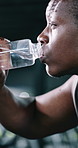Fitness, rest or black man in gym with water bottle, cardio challenge or breathing break in intense practice. Tired, bokeh or athlete with liquid, fatigue or hydration recovery for exercise goals.