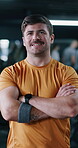 Arms crossed, face and funny with man in gym for commitment to training, vitality or workout. Confident, exercise and fitness with person laughing in health club for dedication or physical challenge