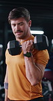 Bodybuilder, weightlifting and man in gym for fitness, training and workout for endurance goals. Dumbbell, person or athlete with arm strength, power exercise or health challenge in sports center