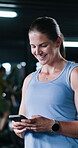 Fitness, typing or woman in gym with phone, message update or results on workout app. Smile, bokeh and female person in center with tech, wellness chat or exercise tracker on training break.