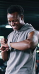 Smart watch, fist pump and workout with black man in gym for performance goals, health app and fitness stats. Wellness, exercise progress and winner with person in sports club for training target