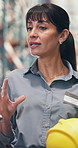 Logistics, discussion or woman with helmet in warehouse, safety training or compliance regulations. Gear policy, accident prevention talk or mature speaker with rules briefing, low angle or education