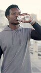 Man, fitness and runner drinking water outdoor for exercise hydration, running recovery and health. Athlete, black person and liquid break in city for cardio rest, thirsty or electrolytes for workout