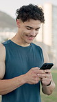 Phone, fitness and man outdoor for running with texting, social media or contact online. Technology, laughing and male athlete with cellphone for chatting on mobile app with cardio workout in nature.
