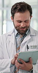 Typing, planning and doctor on tablet in hospital for patient report, diagnosis and treatment. Healthcare, clinic and happy man on tech for medical research, surgery schedule and digital prescription
