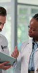 Hospital, doctors and team with tablet, meeting and medical research for treatment plan or services. Clinic, healthcare workers and collaboration with diagnosis report, discussion or people with tech