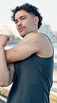 Stretching, fitness and man by beach for running, workout or wellness training on promenade. Sports, boardwalk and male athlete with arm warm up for cardio exercise by ocean for health in morning.