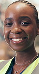 Supply chain, face and black woman in warehouse, smile and career ambition with confidence. African person, inspector and professional in factory, safety vest and pride with distribution or logistics