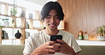 Asian man, student and smile with phone in house for education results, university application or acceptance. Person, tech and good news of study registration, scholarship feedback and notification