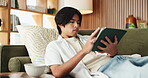 Asian man, student and relax with tablet in house for education results of university application. Person, technology and web portal for study registration, scholarship feedback and review report