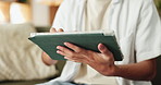 Tablet, hands and man on sofa in home with connectivity, social media or texting on app in living room. Digital technology, swipe and male person with chatting, research or blog in apartment.