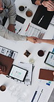 Tablet, paperwork and business people in office shaking hands for finance deal, agreement or partnership. Top view, documents and financial manager with client for handshake with investment contract