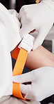 Person, hands and patient with arm strap for medical preparation, IV drip or injection. Closeup, doctor or nurse getting ready with healthcare equipment for health remedy, treatment or procedure