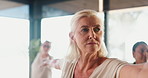 Yoga, senior woman and exercise in class with warrior pose, stretching and holistic wellness. Yogi, elderly people and group practice with balance, health and fitness in active retirement in studio