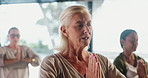 Yoga, woman and instructor in class with meditation, spiritual awareness and speaking for guidance. Mature person, talk and group with prayer hands, namaste pose and mindfulness exercise for peace.