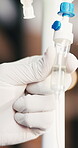 Doctor, hand and iv drip in clinic with wellness medicine, treatment and detox for hydration benefits. Healthcare worker, person and dose with intravenous fluid, natural remedy and homeopathic drugs.