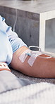 Person, arm and injection with IV drip for blood infusion, vitamins or immune booster in clinic. Closeup, patient and therapy with artery vein or pipe for detox, nutrition or healthcare recovery