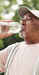 Elderly man, fitness and drinking with water in park for hydration, workout break or recovery. Senior, male person or mineral liquid with aqua bottle for natural sustainability, rest or health