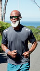 Senior, black man and running with sunglasses for fitness, workout or cardio exercise in nature. Elderly, male person or runner with active movement for health and wellness on outdoor road or street