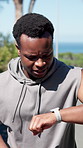 Fitness, black man and running with watch in nature for tracking workout, performance or exercise. Active, male person or runner checking wristwatch with motion app for vitality, health and wellness