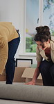 Happy couple, boxes and rolling with carpet for new home, help or interior decor together. Man, woman or homeowners getting ready with rug or mat setup for fun renovation or improvement in house