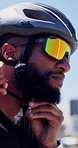 Athlete, man and fasten helmet in city for cycling safety, exercise and getting ready for training. Sunglasses, cyclist and headgear preparation for ride protection, fitness and sports workout