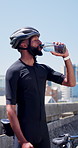 Drinking water, helmet and cyclist outdoor for fitness, hydration and training or practice. African person, nutrition and athlete in city, bottle or thirsty with aqua, minerals and health with detox
