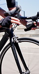 Cycling, hands and man on bicycle outdoor for practice, competition and active on road for journey. City street, cyclist and athlete on bike for sport tournament, travel and eco friendly transport