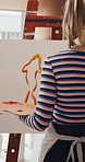 Back, woman and painting in house with easel, diy project and craft process for creative expression. Artist, person and canvas in apartment with talent, illustration skills or paintbrush for artwork.