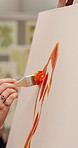 Person, artist and hands with paint brush on canvas for artwork, drawing or creative design. Closeup, creativity or painter with orange color or tools for art project, artistic skill or talent