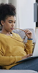 Serious, freelancer and woman with laptop, home and ideas for ebook on sofa, think and typing draft. Creative, ghostwriter and African person with tech for novel, reading and remote work in house