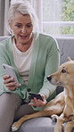 Old woman, phone and credit card with dog on couch for online shopping, relax and care in home. Senior person, smartphone and pet animal with e commerce, fintech or easy payment on app in retirement