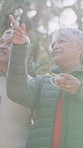Morning, pointing and senior couple in nature with coffee for bonding, conversation and sightseeing. Retirement, marriage and elderly people outdoor for fresh air, relationship and talking with drink