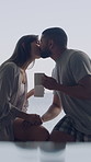 Couple, coffee cup and kiss on balcony with ocean view with bonding, relax or vacation at hotel. Man, woman and smile with partner for beverage, drinks and affection on holiday at seaside resort