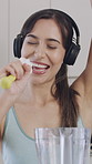 Woman, singing and headphones in home with blender, streaming and citrus juicer for mic in kitchen. Person, happy and audio with karaoke, playful and dancing with smoothie ingredients at apartment
