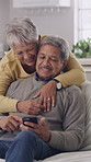 Old man, phone and woman with hug on sofa for bonding, care and discussion with post in home. Happy couple, embrace and smartphone on couch with love, app or social media in retirement at apartment