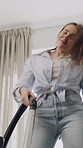 Woman, dancing and cleaning with vacuum at house for hygiene, carpet maintenance and energy. Below, female person and moving with machine, listening to music and rhythm for housekeeping entertainment