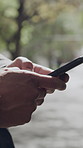 Hands, smartphone and man in city, typing and digital app for social media, internet and texting. Mobile user, outdoor and cellphone for communication, person and network for connection and message